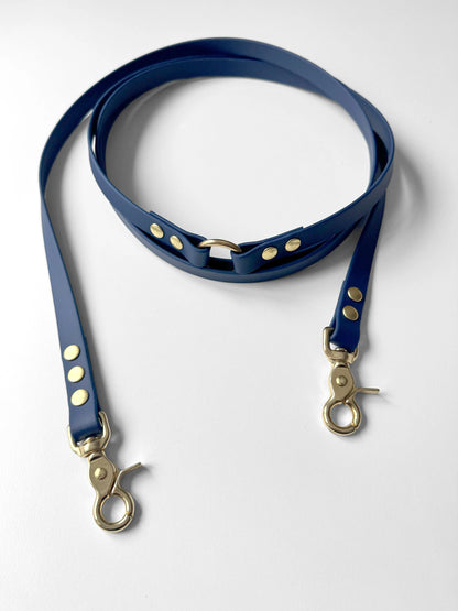 Blue biothane dog leash with gold hardware on a white background Niebieska granatowa smycz z biothane hands-free idealna na spacer